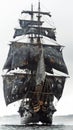 Front view of a black pirate ship vessel piercing through the fog Royalty Free Stock Photo