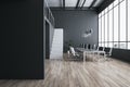 Front view on blank black wall in stylish coworking office with modern computers on light table, wooden floor, white stairway and Royalty Free Stock Photo