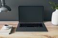 Front view on blank dark modern black laptop monitor with place for web design or site on wooden table with coffee mug, white vase Royalty Free Stock Photo