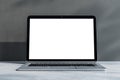 Front view on blank white laptop monitor with place for your logo or text on light grey concrete surface and sunlit wall