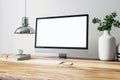 Front view on blank white modern computer monitor with space for web design, web site or landing page on wooden table with white