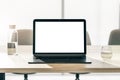 Front view on blank white modern laptop screen with space for your logo or text on wooden table with glass and bottle of water on