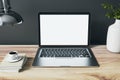 Front view on blank white modern silver laptop screen with space for web design or site on wooden table with coffee mug, white Royalty Free Stock Photo