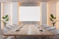 Front view on blank white poster on brick wall in stylish board room with wooden meeting table with modern laptops surrounded by Royalty Free Stock Photo