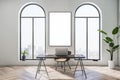 Front view on blank white poster in stylish sunlit home office with city view from arch windows and work table vintage design with Royalty Free Stock Photo