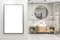 Front view on blank white poster in sunny bathroom with round wooden mirror frame on marble wall, modern light bulbs from top, Royalty Free Stock Photo