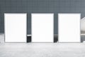 Front view on blank white three advertising billboards with space for your logo or text on concrete floor in abstract industrial Royalty Free Stock Photo