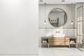 Front view on blank white wall in stylish bathroom with round wooden frame mirror, modern light bulbs from top, wooden sink Royalty Free Stock Photo