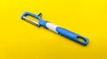 front view of blue fruit and vegetable peeler on yellow background. diagonal position Royalty Free Stock Photo