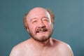 Front view blue isolated aged man in good mood smile joyful eyes naked torso bald mustache beard. Royalty Free Stock Photo