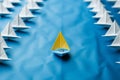 Front view of a blue paper boat amid a white armada