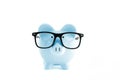 Blue piggy bank in in glasses on white Royalty Free Stock Photo