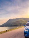 Front view of blue SUV car with opened car truck parked on asphalt road at dam. Summer road trip travel. Car parked on the road Royalty Free Stock Photo