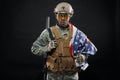 Brave African soldier posing with national flag on shoulder.