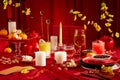 Front view of a brilliant banquet table with candles, wine, yellow apricot flowers and tangerines. Tet atmosphere with red