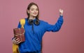 Brunette schoolgirl standing, raising hand, strong. Royalty Free Stock Photo