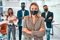 Front view of business people wearing protective masks in the office during the quarantine period