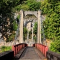 Front view of the carriageway of a bridge and cliffs and forest in the background.