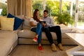 Happy young couple using tablet computer on sofa at home Royalty Free Stock Photo