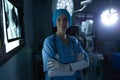 Female surgeon with arms crossed looking at camera in operating room Royalty Free Stock Photo