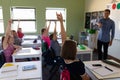 Male school teacher standing in an elementary school classroom with a group of school children Royalty Free Stock Photo