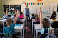 Male school teacher standing in an elementary school classroom with a group of school children Royalty Free Stock Photo