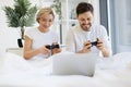 Front view of caucasian playing video games while lying under blanket at home. Royalty Free Stock Photo