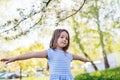 A cheerful small girl playing outside in spring nature. Royalty Free Stock Photo