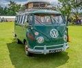 Isolated classic and vintage VW camper van in a green field