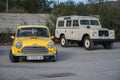 A classic yellow Morris Mini Cooper S 1300 and a Land Rover Santana Series III Royalty Free Stock Photo