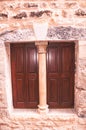 Closed, pair of, colorful, brown, wood, window shutters, with a carved stone column