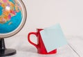 Front view close up globe map world earth coffee cup sticky note lying retro vintage rustic old table background Royalty Free Stock Photo