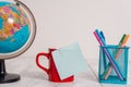 Front view close up globe map world earth coffee cup sticky note pens metal holder lying retro vintage rustic old table Royalty Free Stock Photo