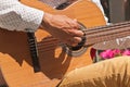 Young man`s hand strumming a guitar in Madrid, Spain