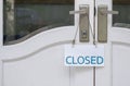 Closed sign plate hanging on door handle of the old white vintage door Royalty Free Stock Photo