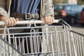 Front view closeup with a selective focus of a teenage girl moving a shopping cart outside a supermarket Royalty Free Stock Photo