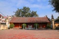 Front view of a communal house in a village in Vietnam with big old Ficus religiosa tree and Banian tree. Royalty Free Stock Photo