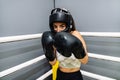 Woman with protective gloves and headgear in attack position on a ring boxing Royalty Free Stock Photo