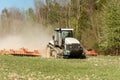 Front view of a crawler tractor during sowing. Harrowing soil in the field