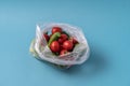 Front view Cucumbers and tomatoes in plastic bag on blue background. Image shows the harmness of using artificial food storage