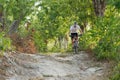 Front view of The cyclist is riding on mountain bike on rocks trail in forest. Royalty Free Stock Photo