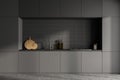 Front view of dark grey modern kitchen interior with kitchenware. Concrete floor. Black ceramic tiles on wall Royalty Free Stock Photo