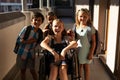 Disable schoolgirl with classmates looking at camera in hallway Royalty Free Stock Photo