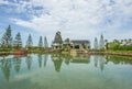 Exterior view of Dutch style shops Windmill and Reflection of Pine trees in shiny water Royalty Free Stock Photo