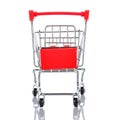 Front view of empty chromed toy market shopping cart with red handle and plastic board. White background with reflection on the Royalty Free Stock Photo