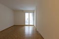 Front view of an empty room with white walls and parquet. There is a window overlooking the balcony Royalty Free Stock Photo