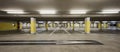 Front view empty underground supermarket parking with yellow concrete columns and white arrow on the ground Royalty Free Stock Photo