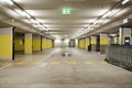 Front view empty underground supermarket parking with yellow concrete columns and white arrow on the ground Royalty Free Stock Photo