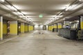 Front view empty underground supermarket parking with yellow concrete columns and white arrow on the ground Royalty Free Stock Photo