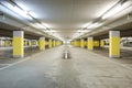 Front view empty underground supermarket parking with yellow concrete columns and white arrow on the ground Royalty Free Stock Photo